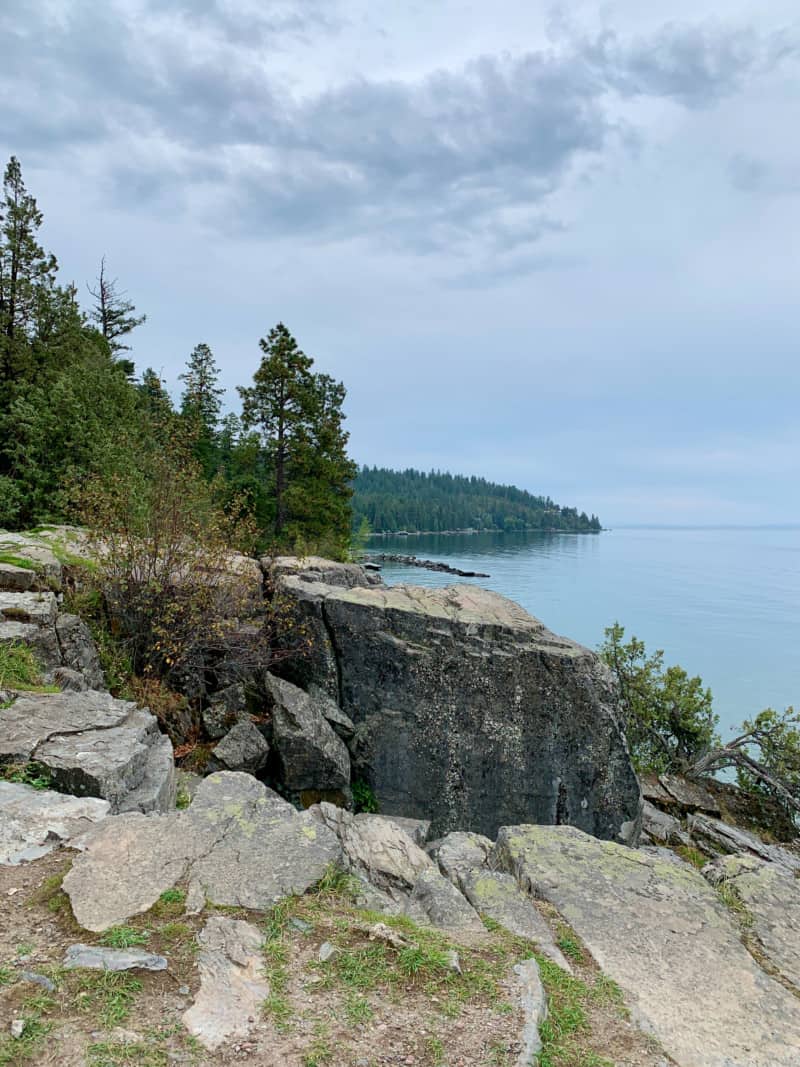View of the rocky, pine-covered shoreline of Lake Flathead, Montana